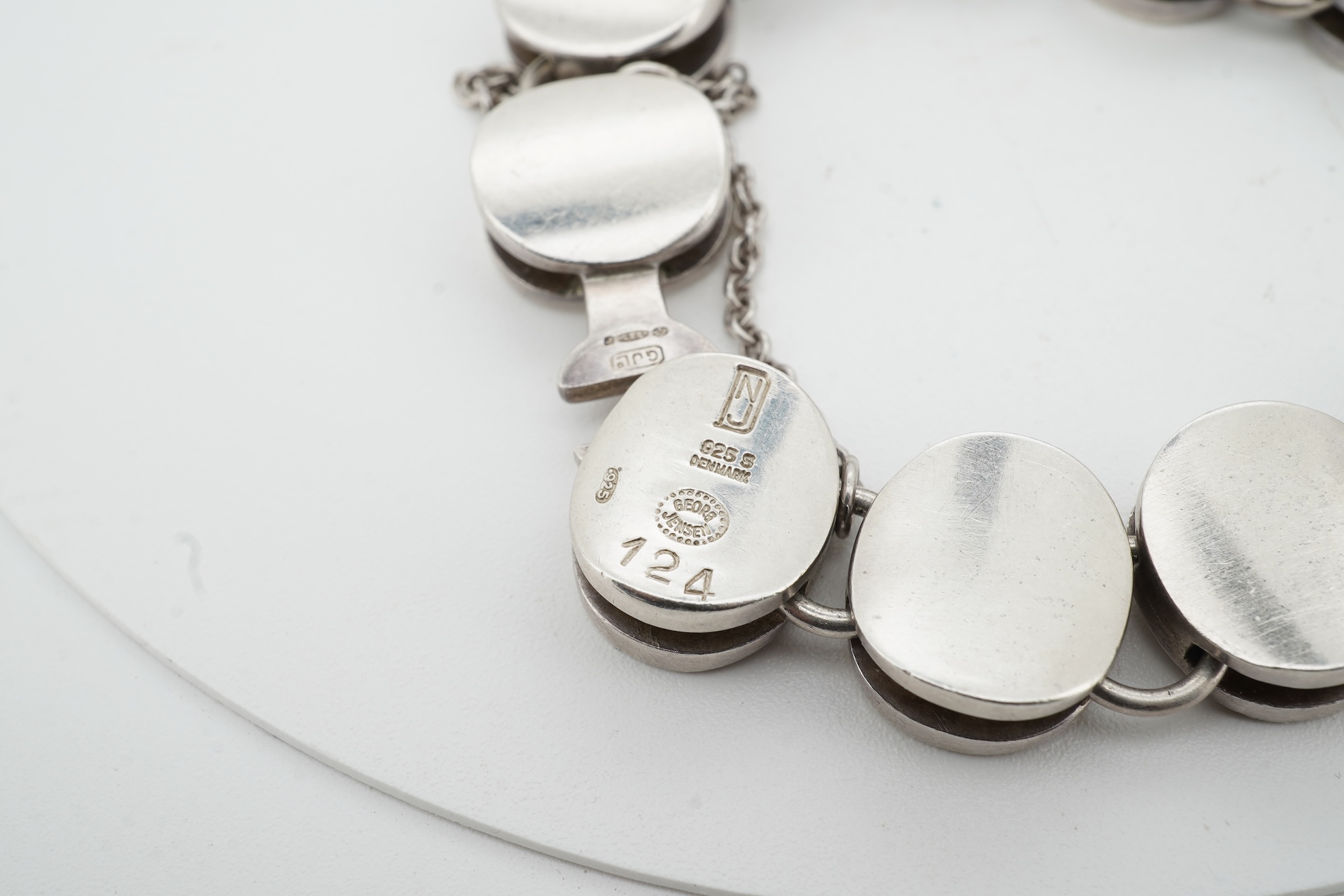 Nanna Ditzel for Georg Jensen, a silver bracelet, circa 1972, and a Georg Jensen ring, circa 1968, the bracelet composed of polished oval links with a concealed hoop clasp, length approximately 17cm, signed Georg Jensen,